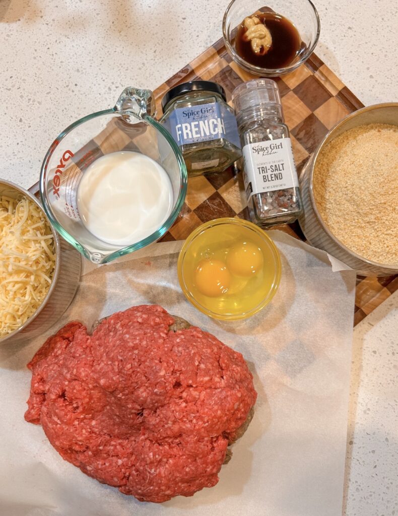French onion meatloaf ingredients with ground beef, breadcrumbs, eggs, milk, Gruyère, and seasonings