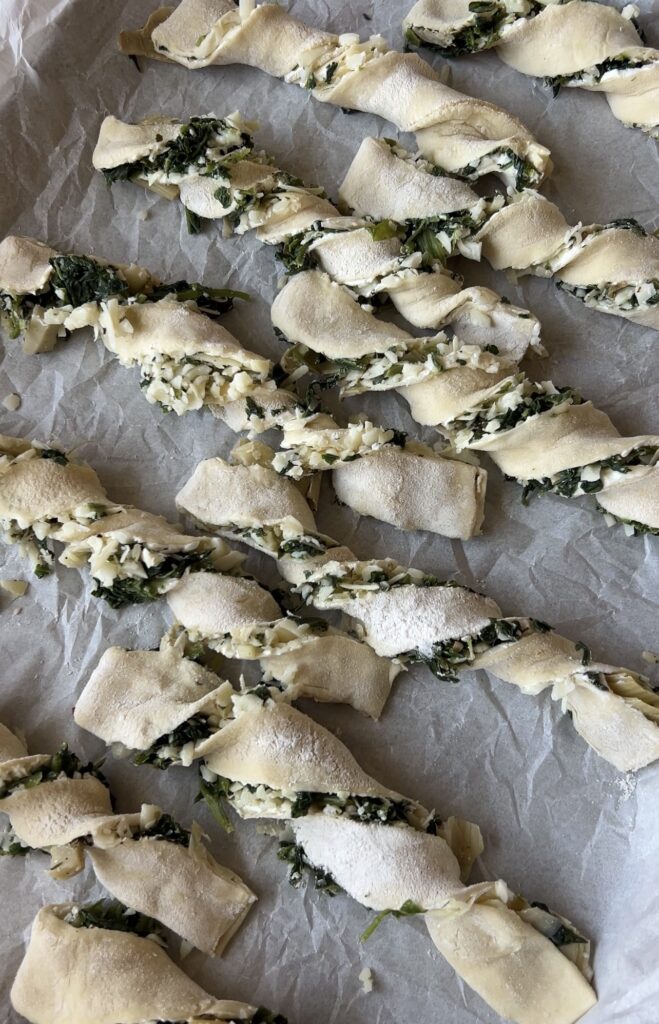 Spinach artichoke puff pastry strips twisted before baking