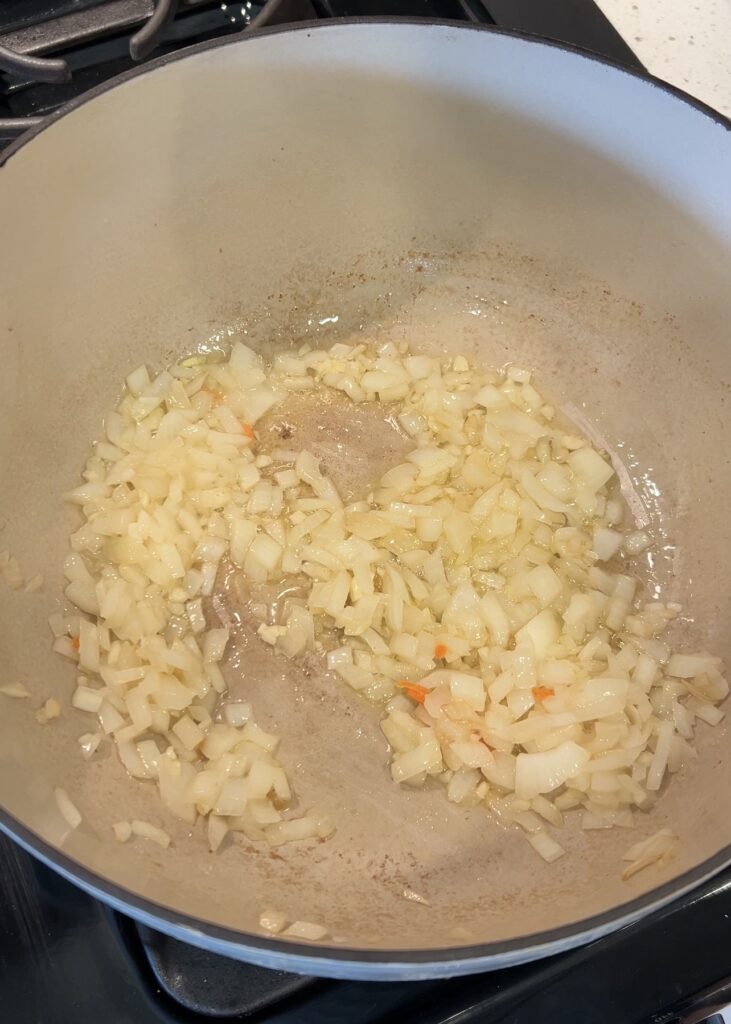 Diced onion and garlic sautéing in butter for broccoli cheddar soup