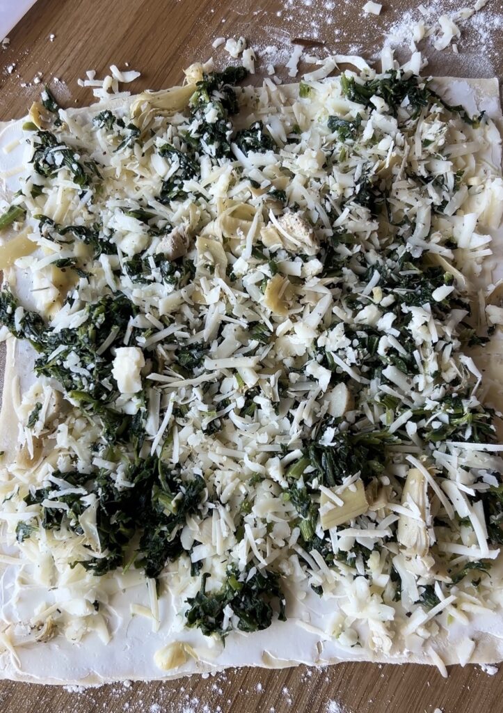 Spinach artichoke filling spread evenly to the edges of puff pastry