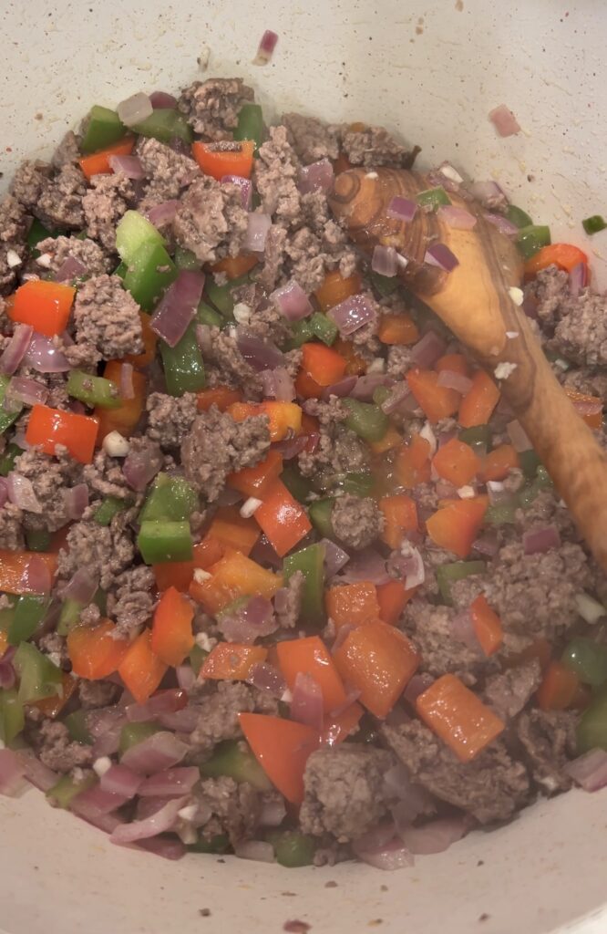 Red onion, poblano, jalapeño, and bell pepper sautéing with ground beef for taco soup