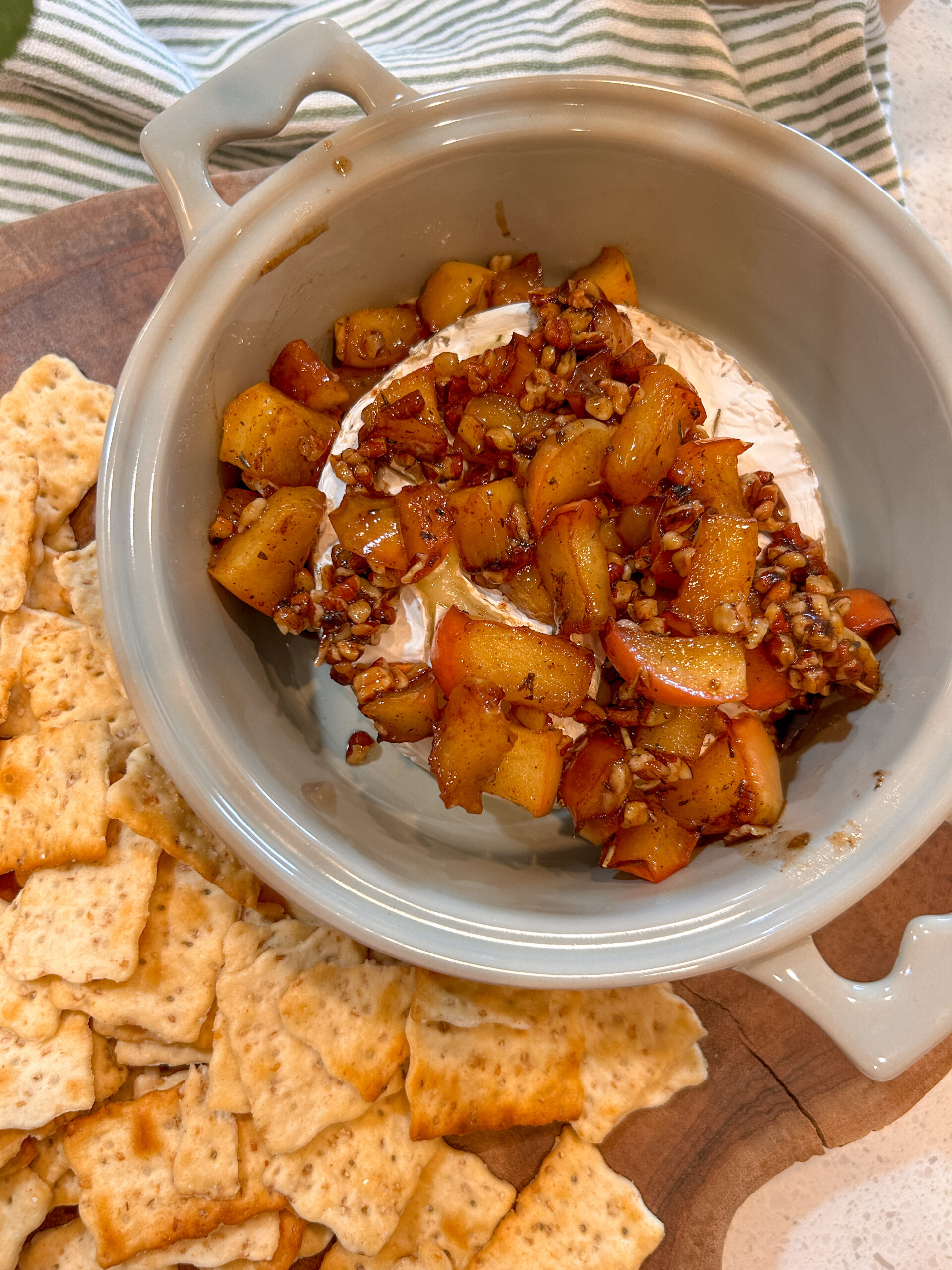 Baked Brie with apples, toasted pecans, and maple topping served with crackers