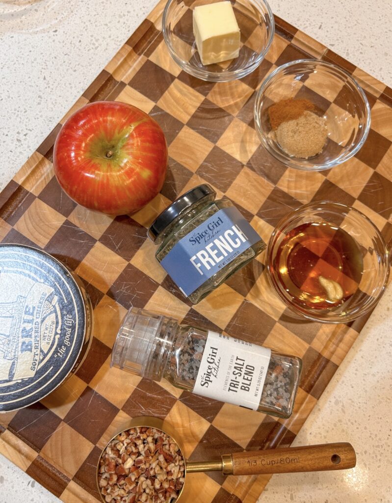 Ingredients for baked Brie with apples, pecans, maple syrup, and French Seasoning