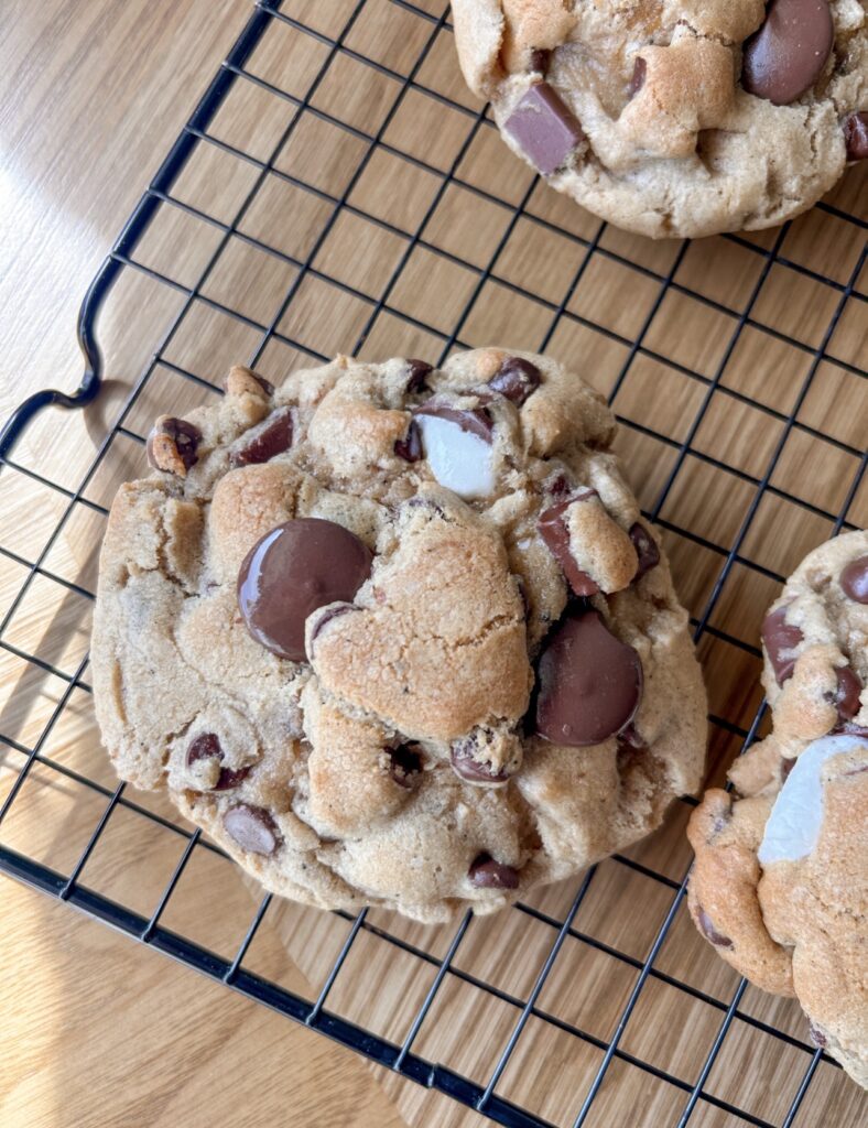 Bakery style brown butter s’mores cookies cooling on a wire rack