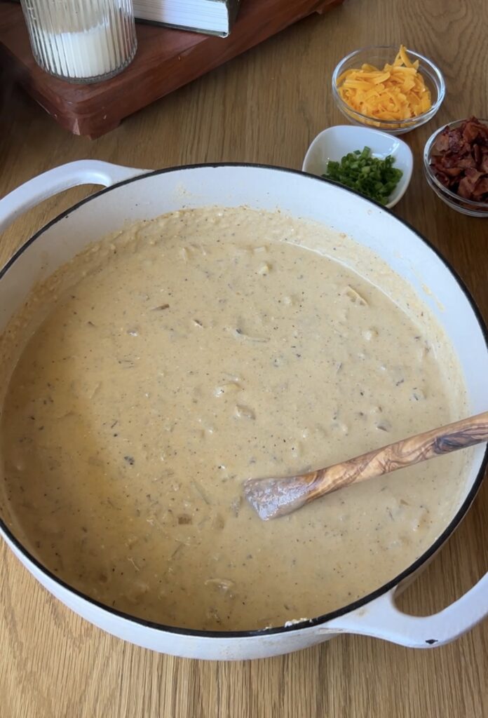 Stirring sour cream and sharp cheddar into loaded baked potato soup