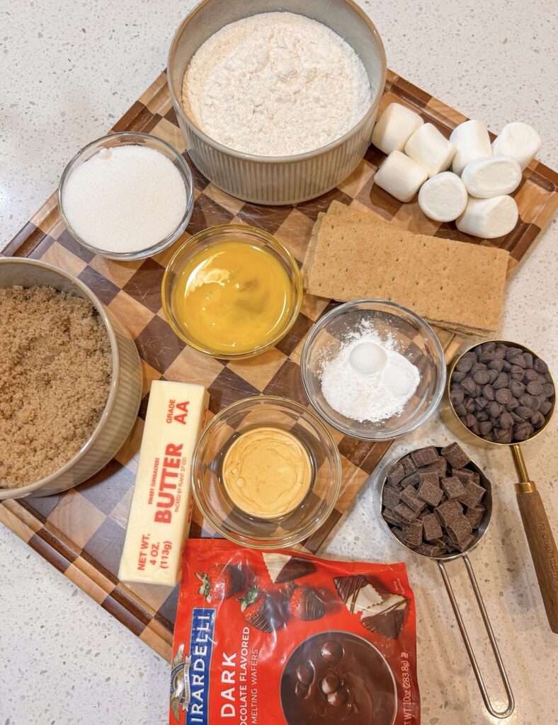 Ingredients for bakery style s’mores cookies including chocolate chips, marshmallows and graham crackers