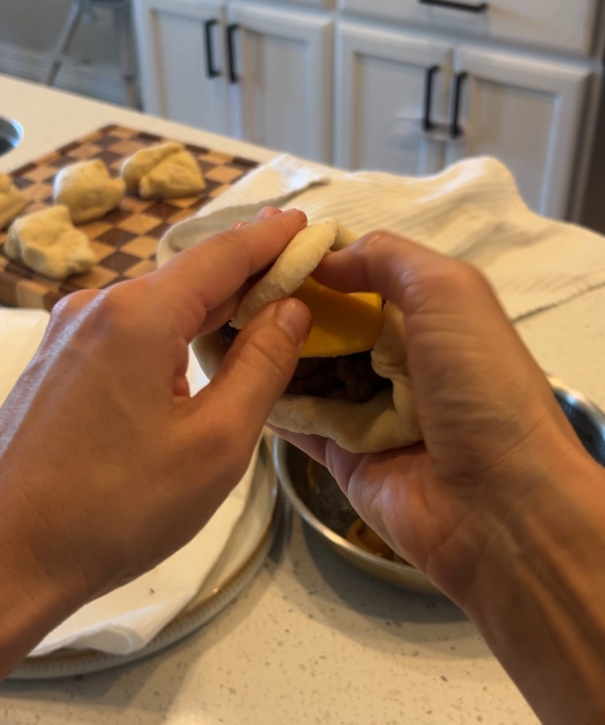 Homemade dough filled with a burger patty, cheese, caramelized onions and pickles