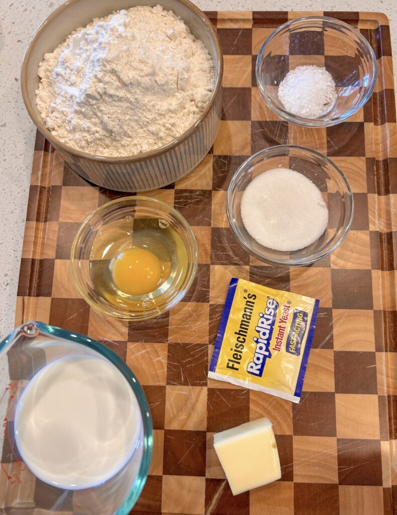Ingredients for homemade cheeseburger bomb buns, including bread flour, yeast, sugar, egg, milk and butter