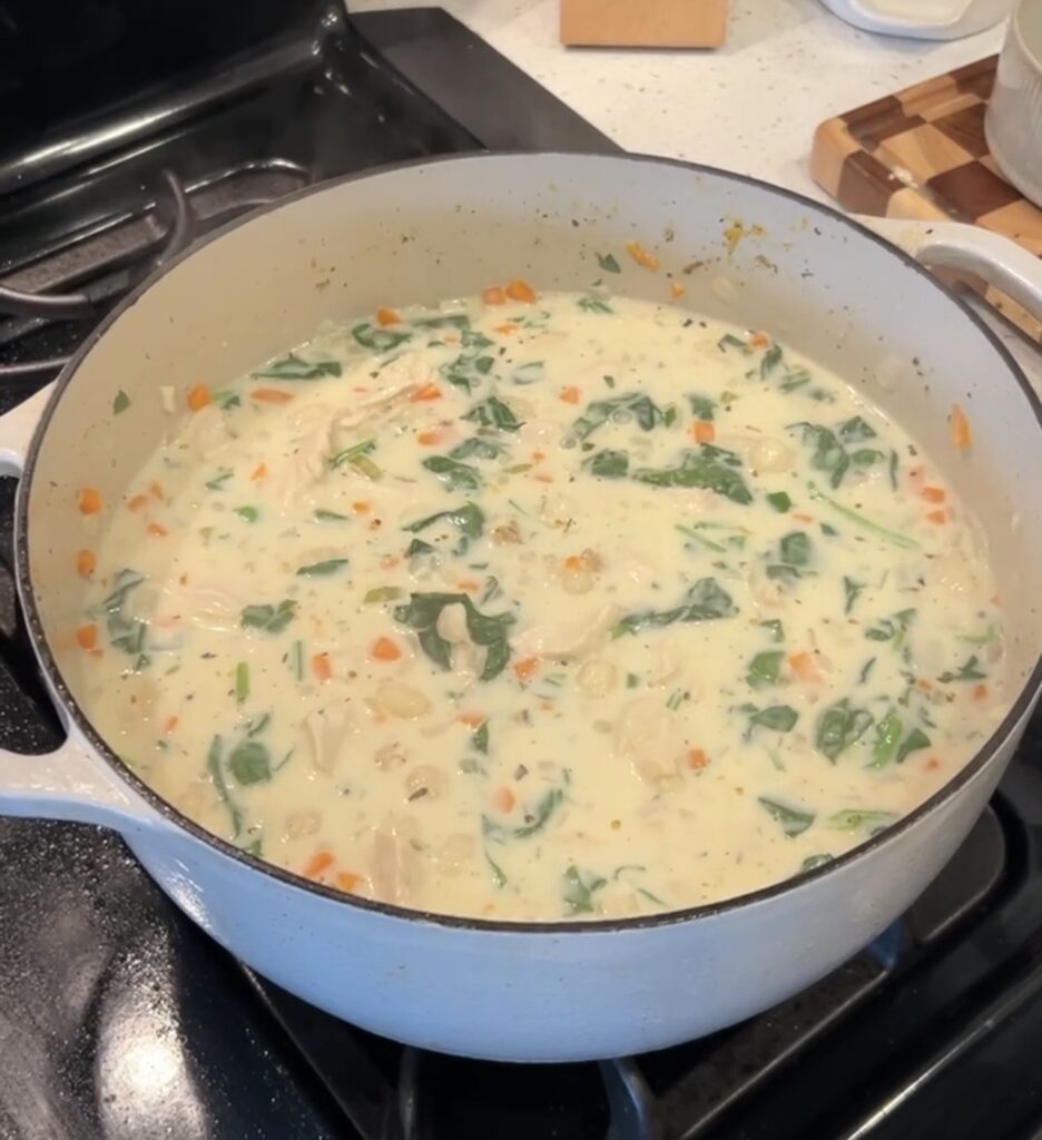Finished chicken gnocchi soup with shredded chicken, spinach, half-and-half, and Parmesan.