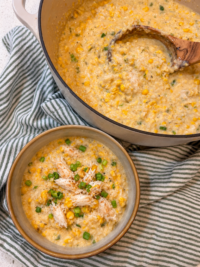 Corn and crab bisque topped with green onions in a serving bowl.