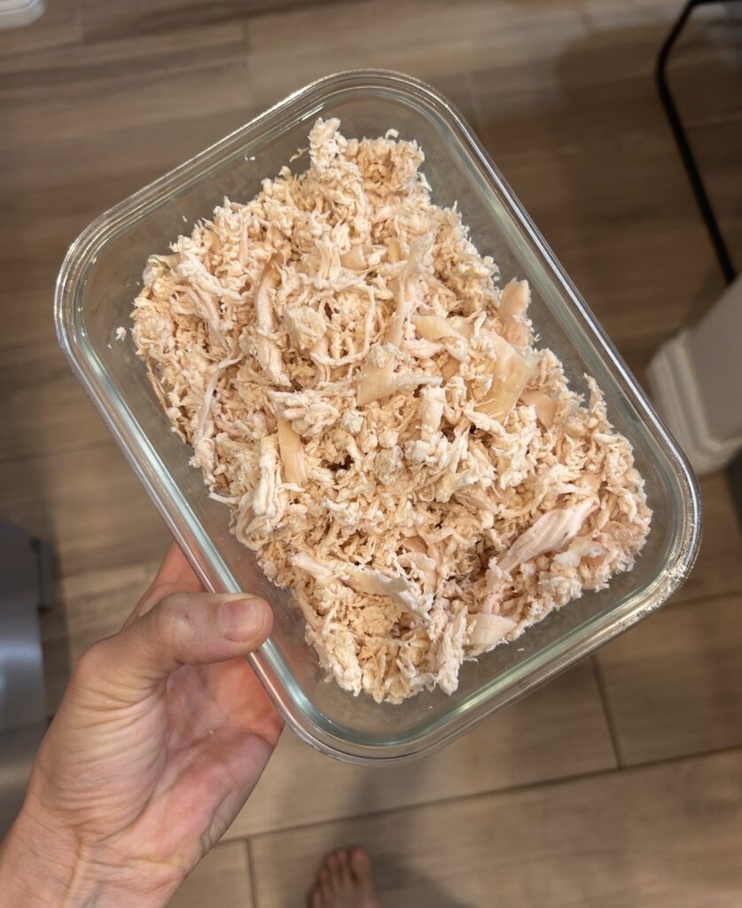 Finely shredded cooked chicken prepared for buffalo chicken hand pie filling.