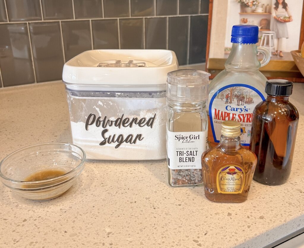 Ingredients for maple bourbon glaze including powdered sugar, maple syrup, bourbon, vanilla, and browned butter.