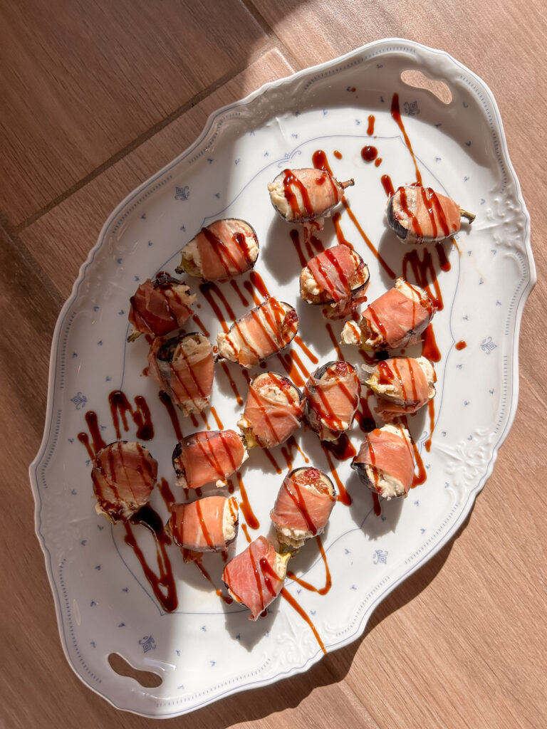 Balsamic glaze drizzled over warm prosciutto wrapped figs stuffed with creamy Boursin cheese.