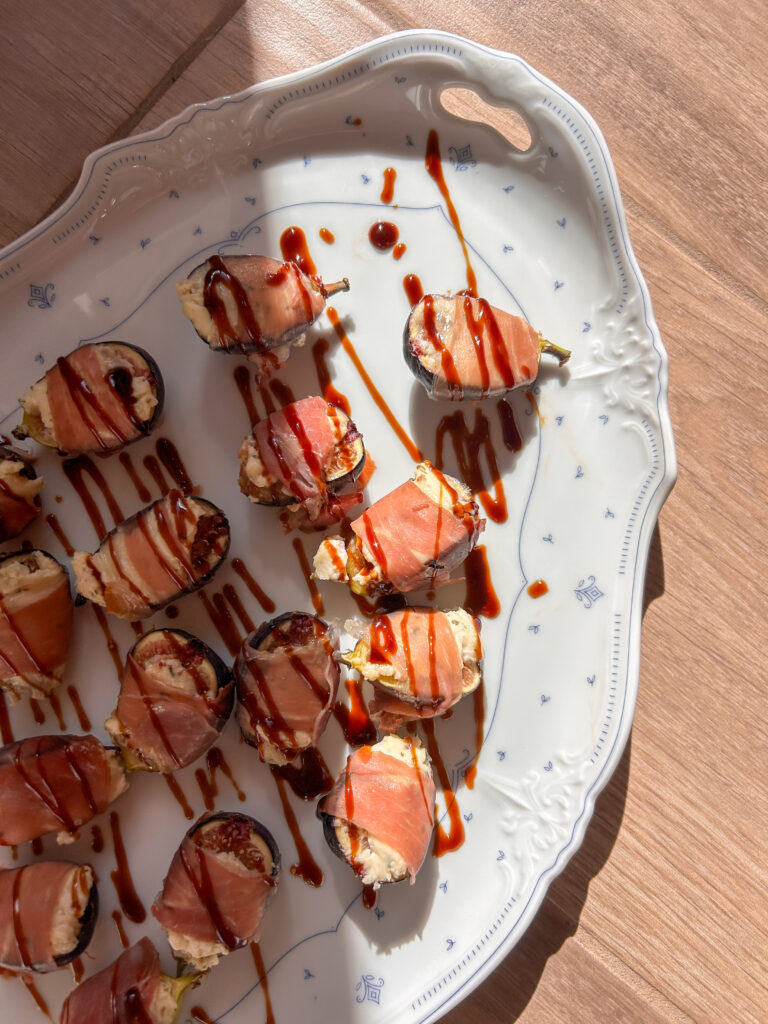 Prosciutto wrapped figs stuffed with creamy Boursin cheese and drizzled with balsamic glaze.