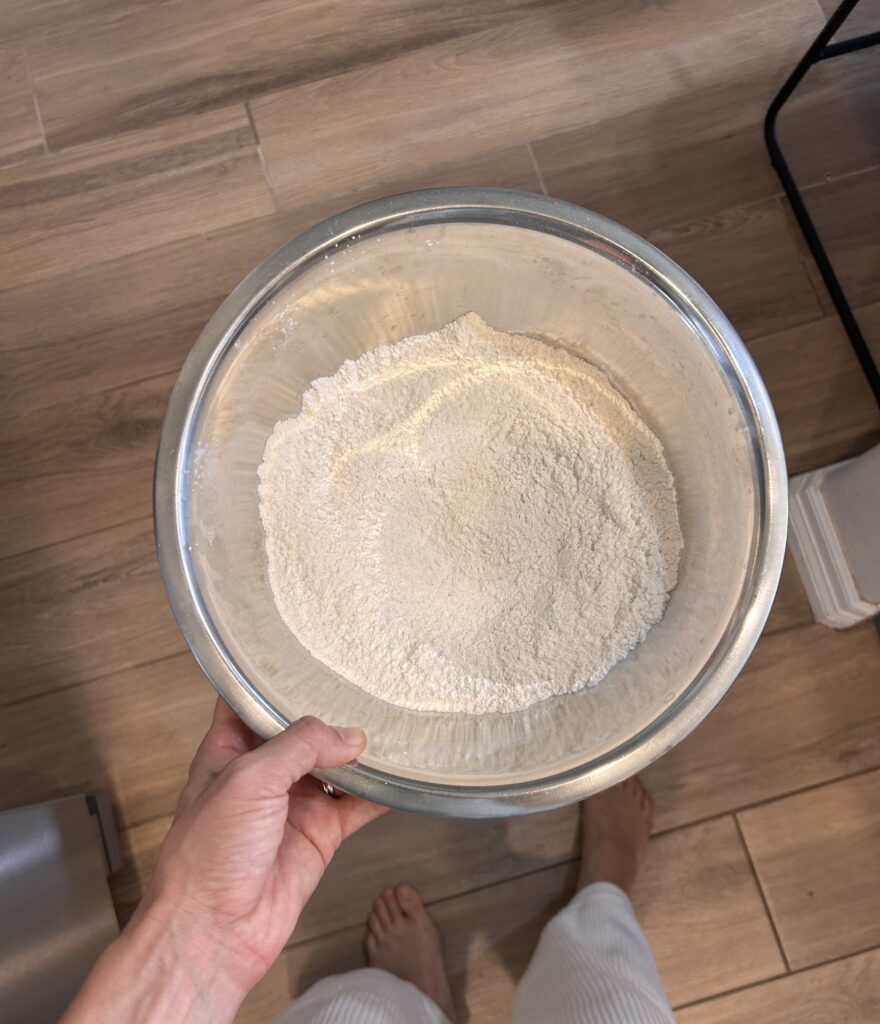 Flour, cornstarch, baking powder, baking soda, cinnamon, and nutmeg combined in a mixing bowl.