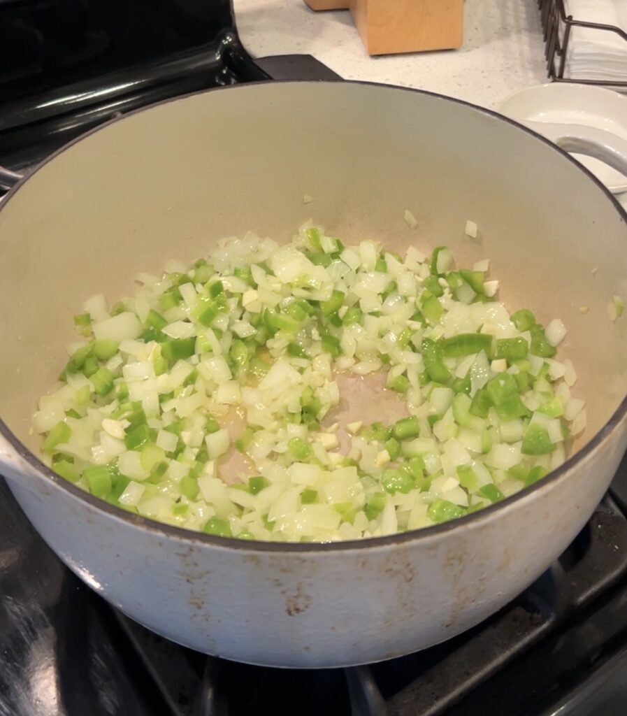 Diced onion, celery, and green bell pepper sautéing in butter.