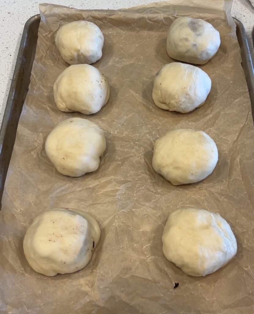 Dough gathered and pinched around the cheeseburger filling to seal each bomb