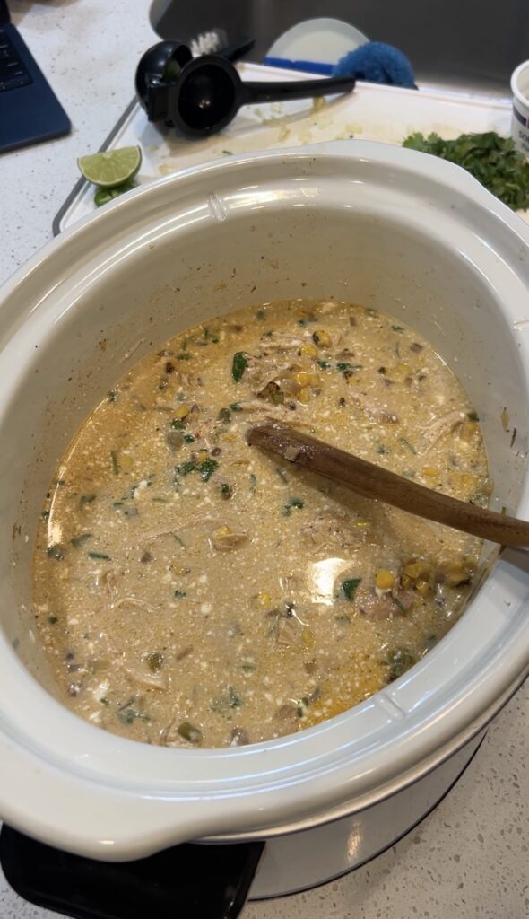Mexican street corn soup in the slow cooker after adding the creamy cheese mixture, lime, and cilantro.